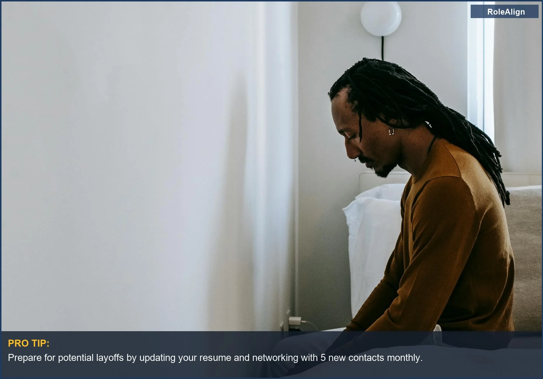 Sad young Black man with dreadlocks contemplates his future after a layoff.