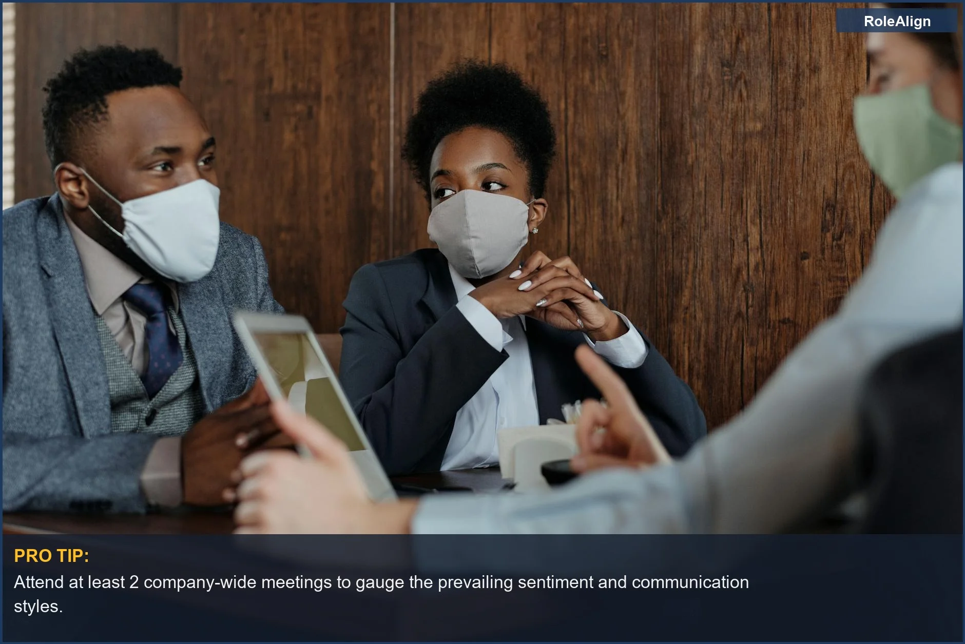 Masked team discussing strategies in a meeting room, demonstrating adaptability in workplace culture.